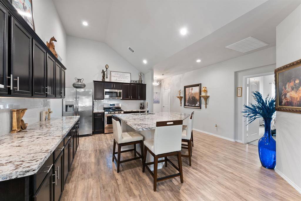 This kitchen offers a large island featuring a built-in sink and ample seating, making it the perfect for dining, and socializing.