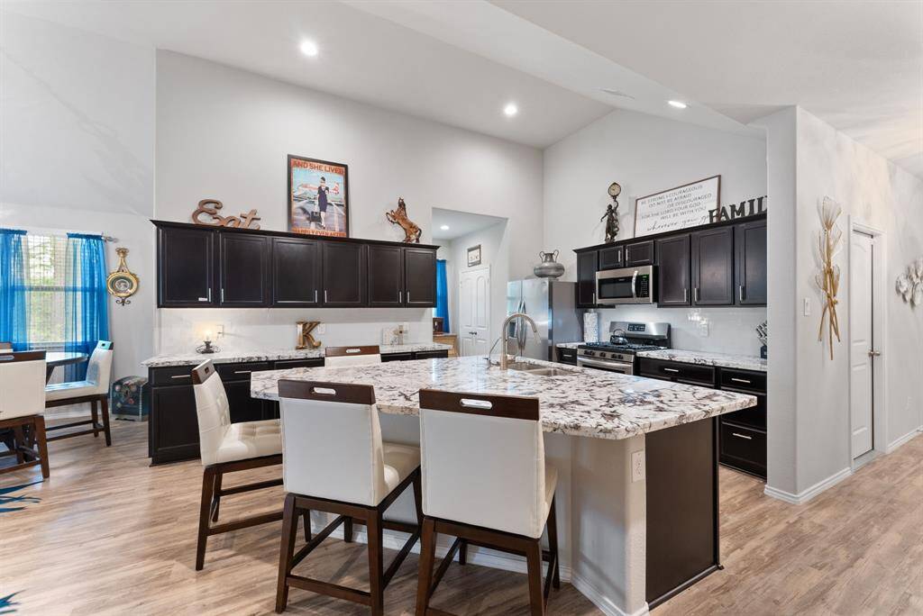 The kitchen features a spacious island that seamlessly connects to a bright breakfast area
