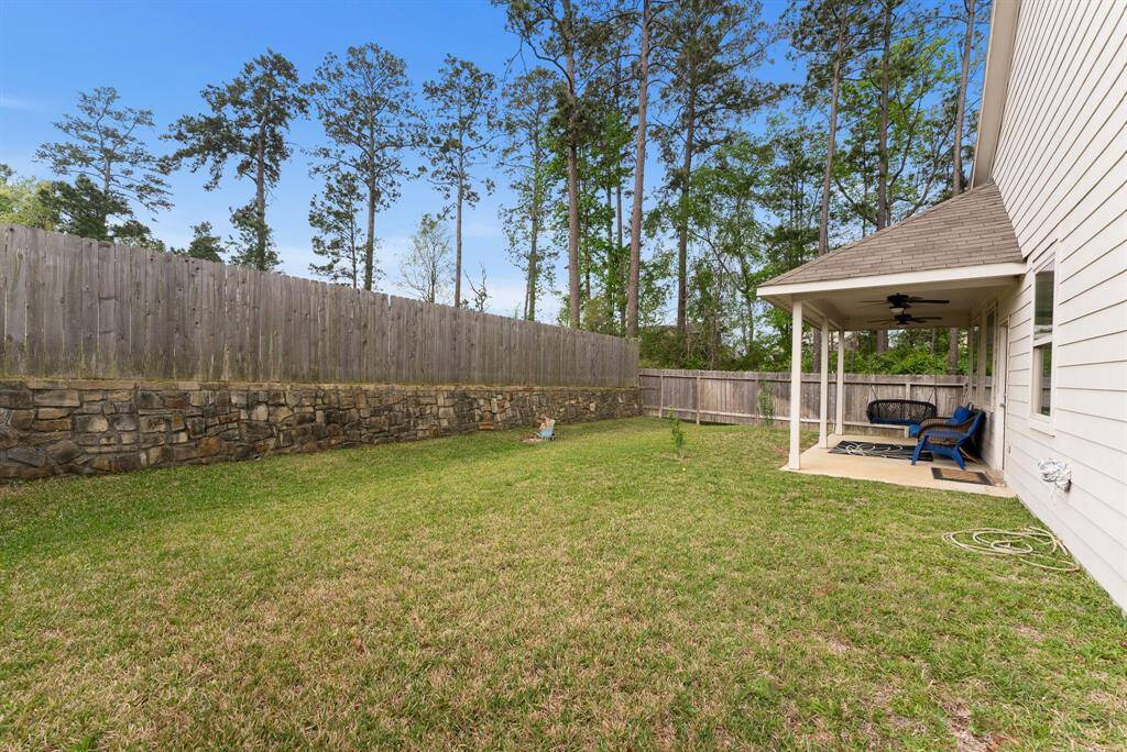 The backyard features a beautiful stone base fence, adding both character extra privacy