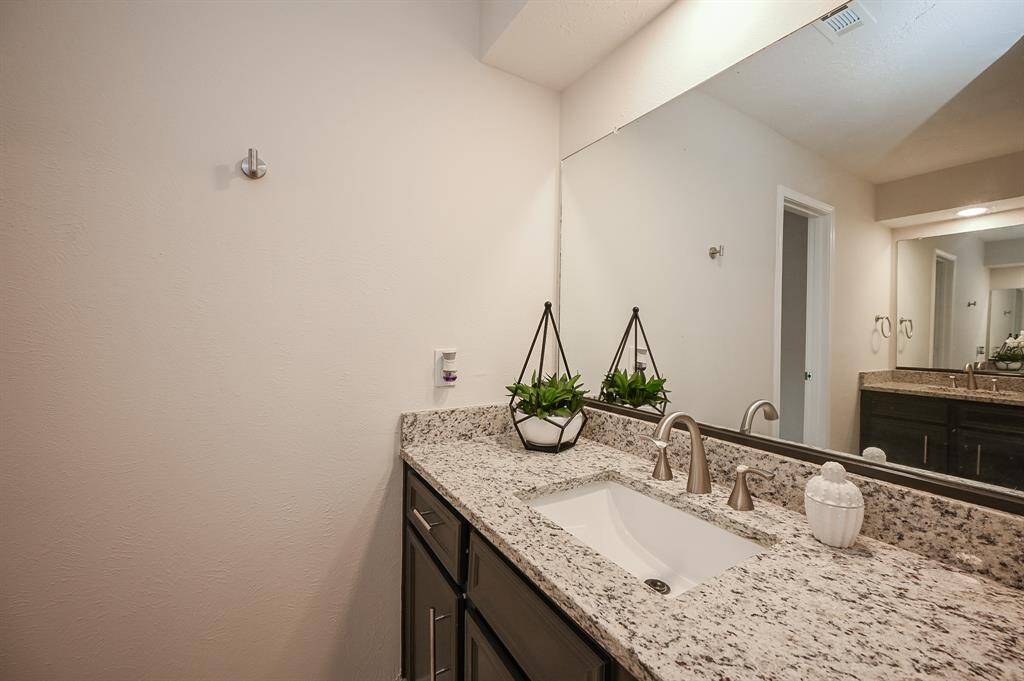 Primary bathroom has dual sinks!  This bathroom has all new flooring, new granite counters, new sink and faucet, and new hardware