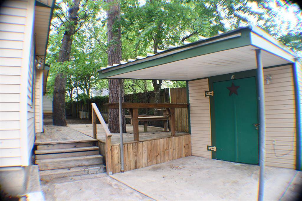 The back of the house has a very large wooden deck and three storage sheds.