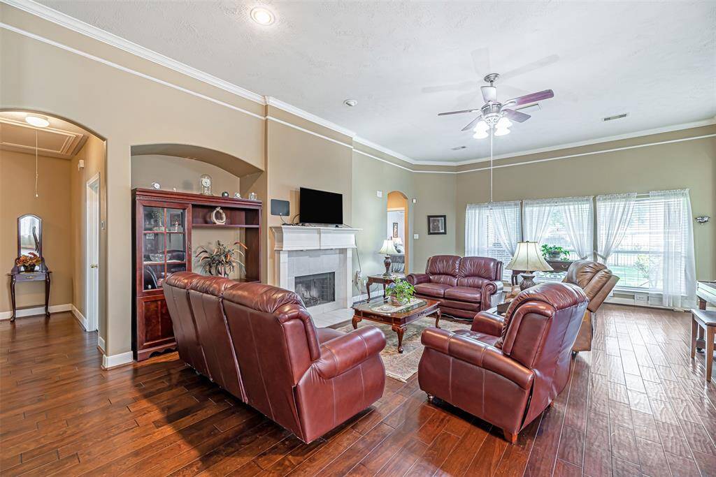 Spacious family room with continued wood flooring and decorative trim and crown molding.