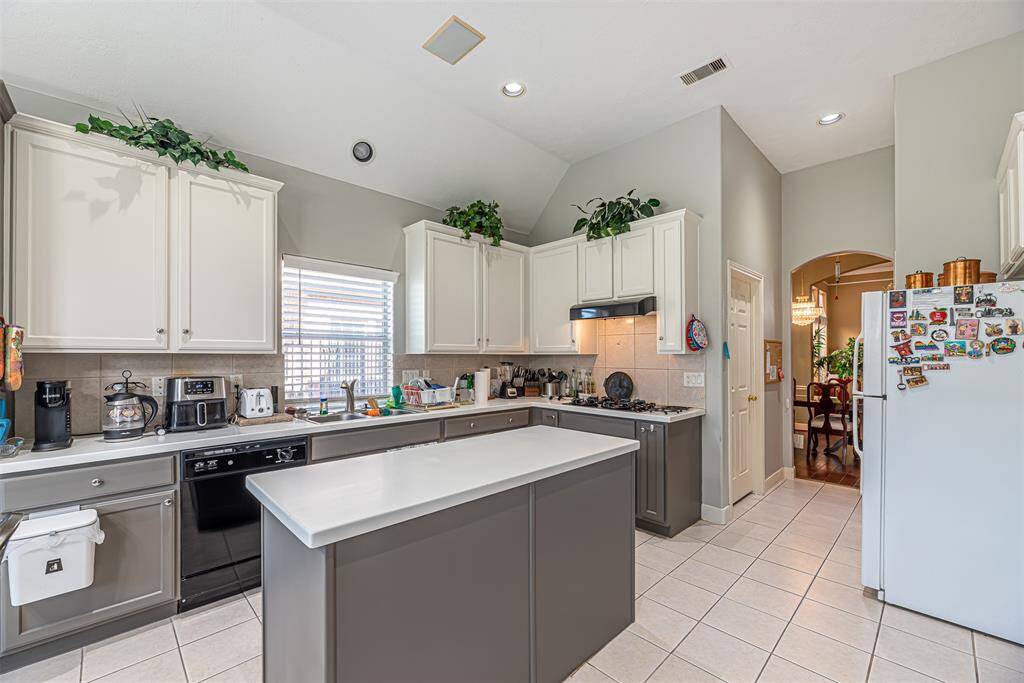 The kitchen also features two tone cabinets, island, gas range and plenty of storage and counter space.