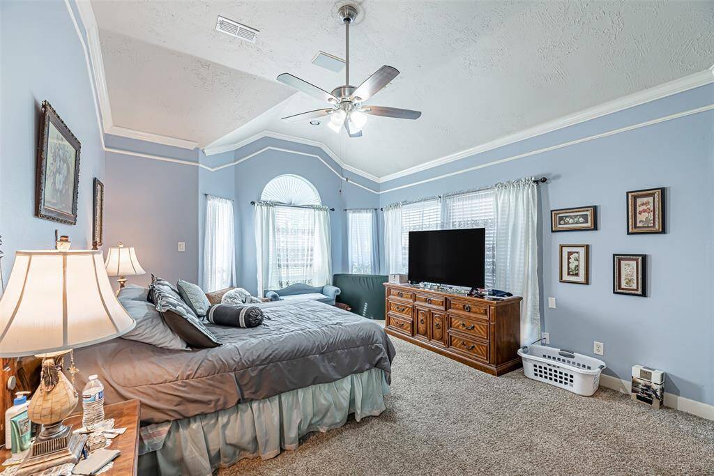 Additional view of the primary bedroom with carpet and large windows for natural light.
