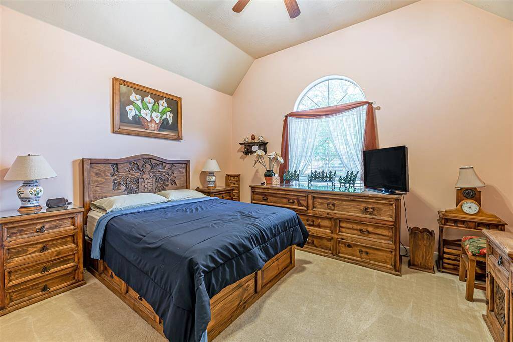 Secondary bedroom features carpet, ceiling fan and picture window.
