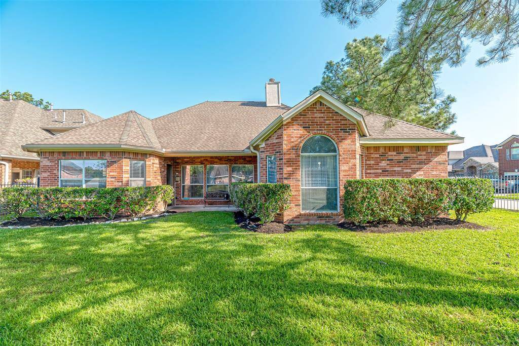 Spacious backyard with covered patio area and shrubs for privacy.