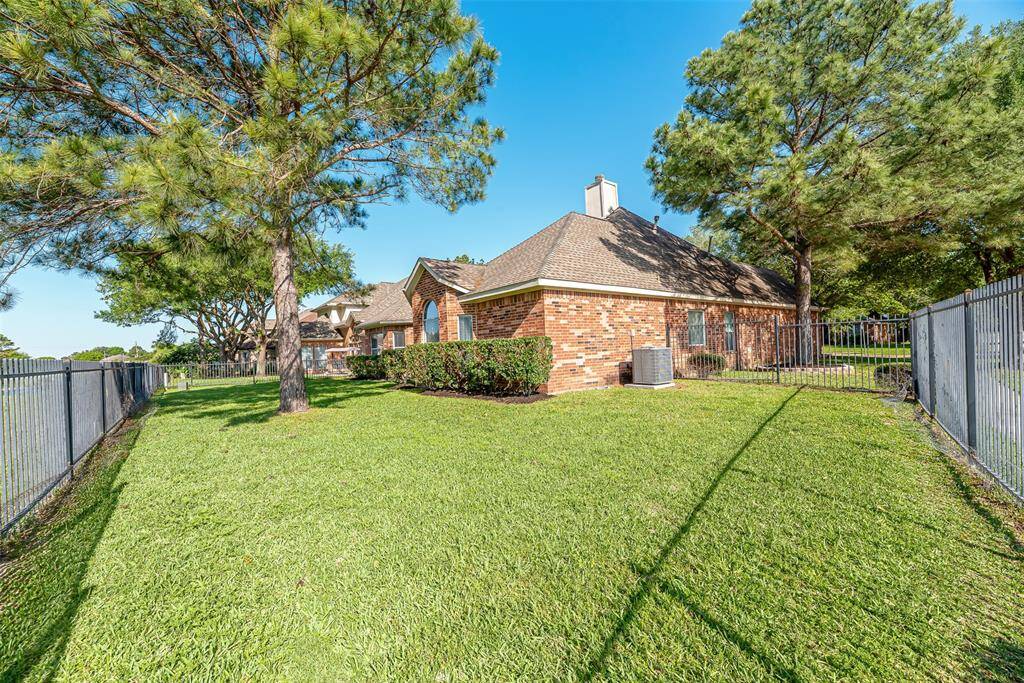 Lots of yard for the kids and pets to play in this backyard with black rod iron fence.
