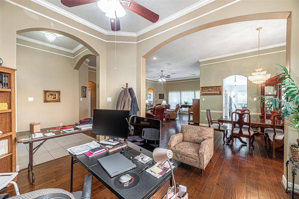 The study can also be used as a formal living/sitting area. It features arched doorways, ceiling fan and wood flooring.