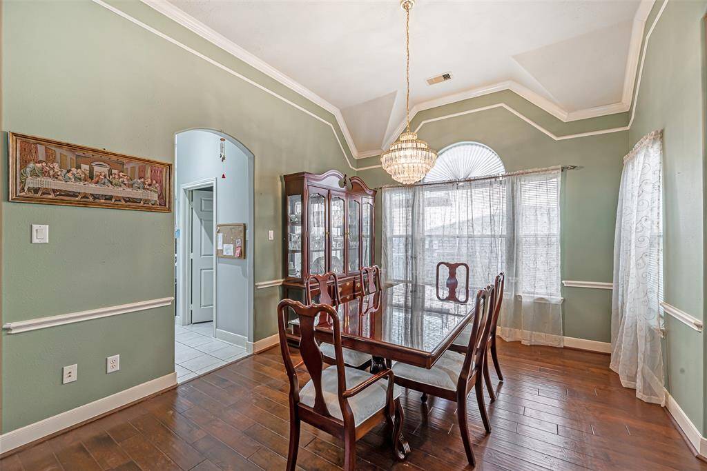 The dining room is just off the kitchen and features chandelier, crown molding, chair rail and other decorative trim.