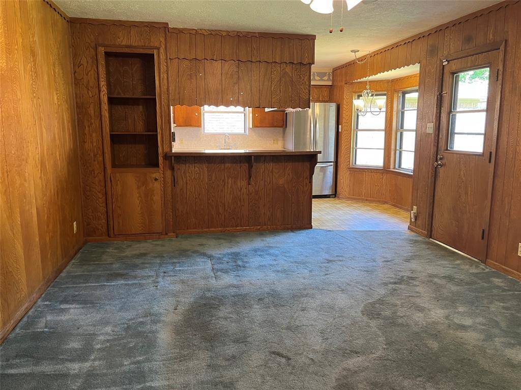As we enter the family room, you can see it opens to the breakfast area and kitchen. The carpet is not wet and has never flooded. It had a very thick pad that has been worn down after years of traffic in the same areas.