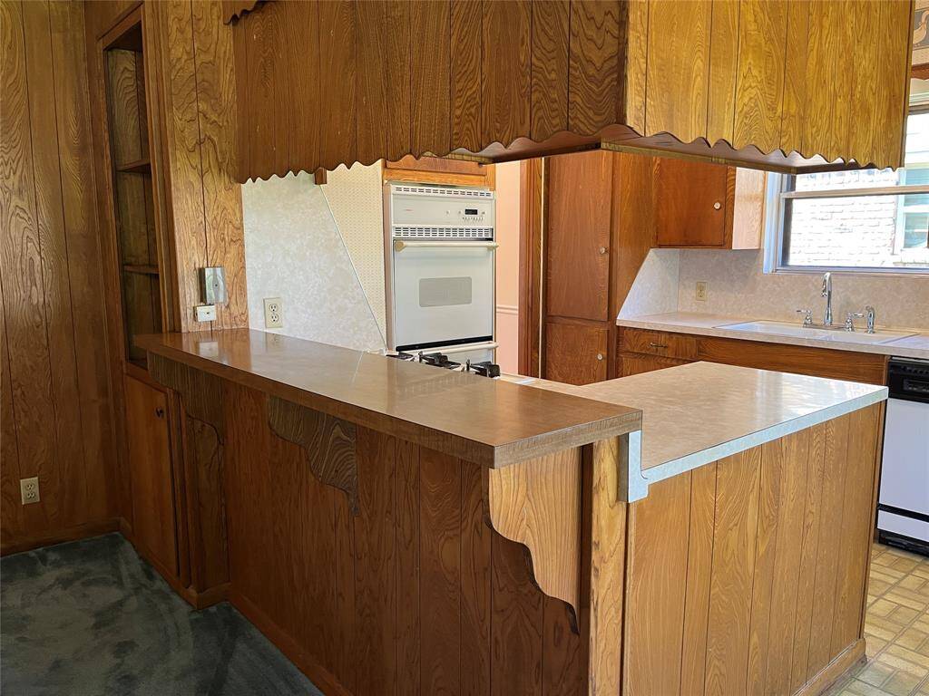 The breakfast bar is shown, as well as the built-in bookcase to the far left. If you wanted to open the kitchen a little bit, you might remove the bookcase and reconfigure a few things.