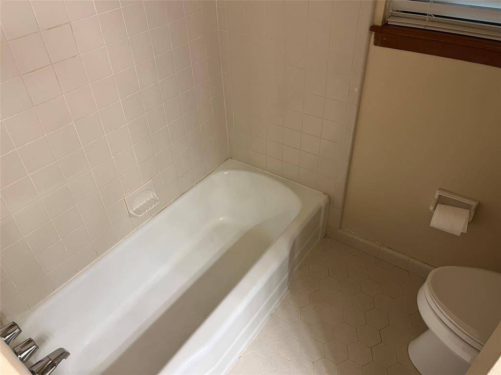 The tub/shower is shown and you have nice honeycomb tile on the floor. There's a little partition that gives privacy at the lavatory.