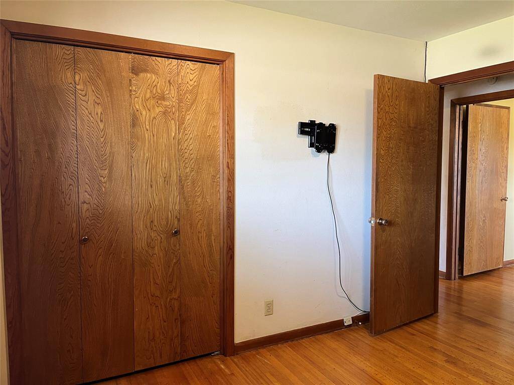 Here's the reach in closet for the second bedroom. You also get a wall mount TV bracket. The primary bedroom is visible through the open door across the hall.