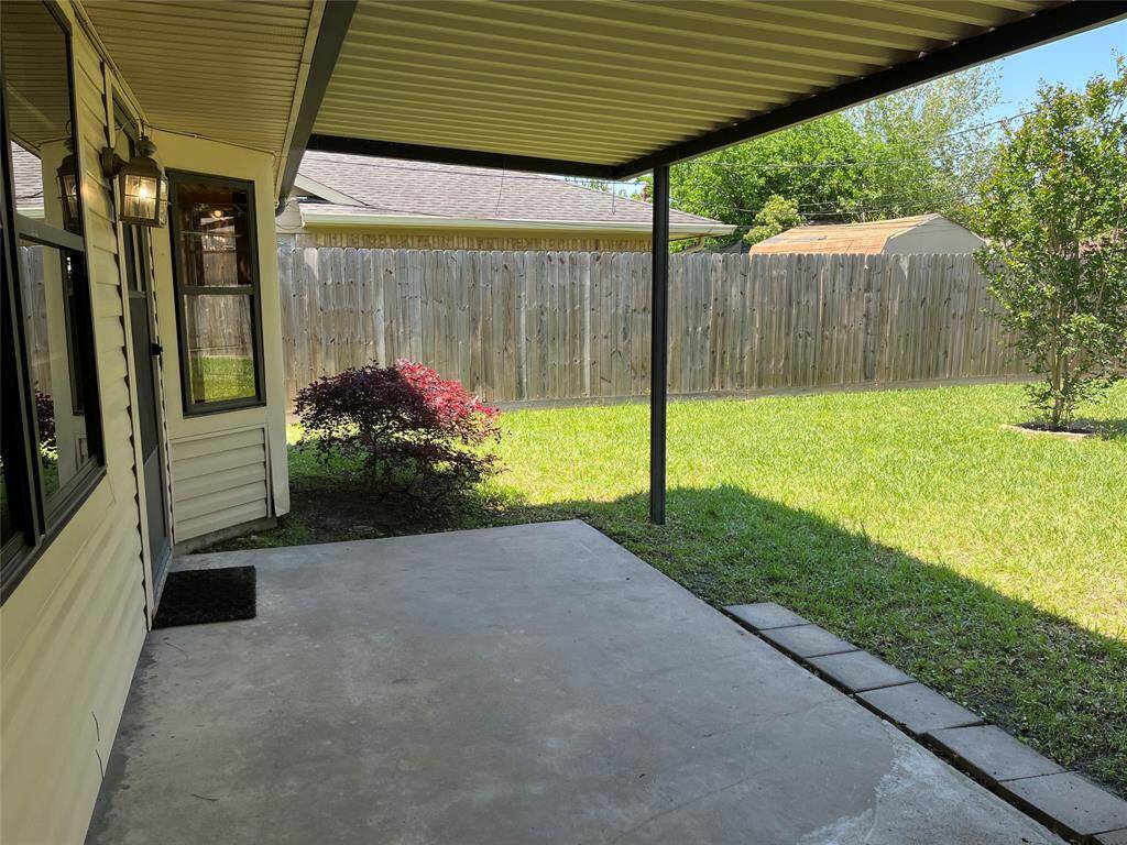 Here's another look at your covered patio. This is taken by the door to the garage. The home has brick and vinyl siding. You can see the storm windows here.