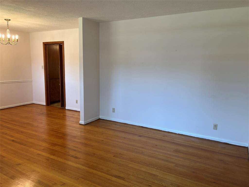 The dining room area is defined by the little wall and it has a cool vintage chandelier. The doorway leads to the kitchen.