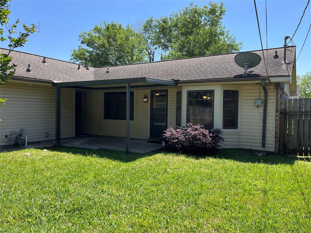 The back of the house is shown here. The roof was installed in 2016. There's a front fence on the side of the house, but the garage side is open.