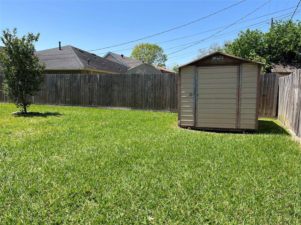 The Morgan storage building sits at the back corner of your lot. You can see the two side fences.