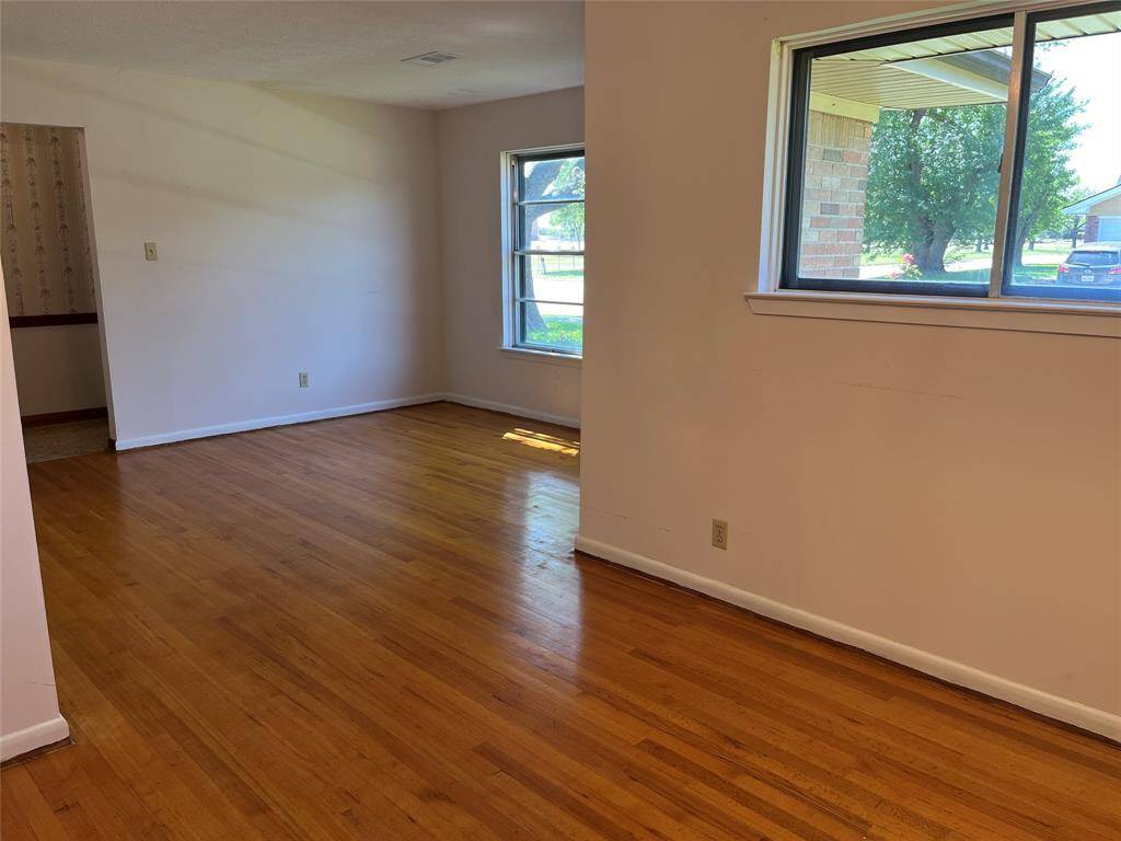 This is taken from near the kitchen doorway, looking through the formal dining room and formal living room toward the front door and foyer.