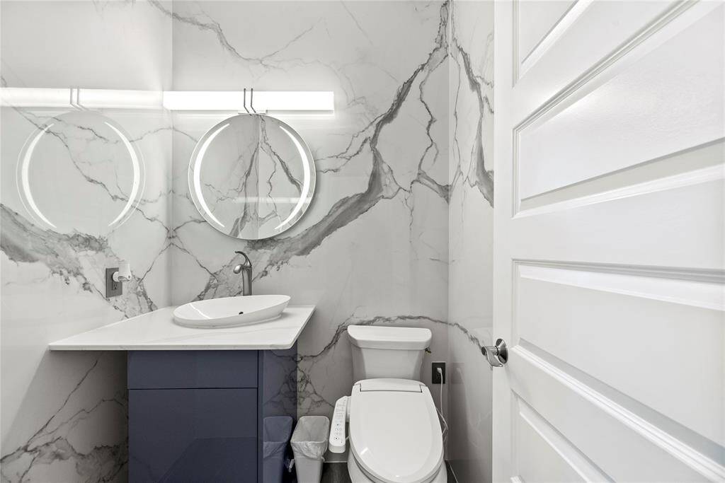 Downstairs half bathroom boasts a lighted mirror, Quartz vanity and bidet.