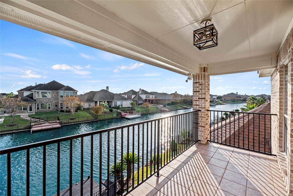 Private balcony with stunning waterfront views, perfect for enjoying quiet mornings or evening sunsets, complete with a charming light fixture and ample space for relaxation.