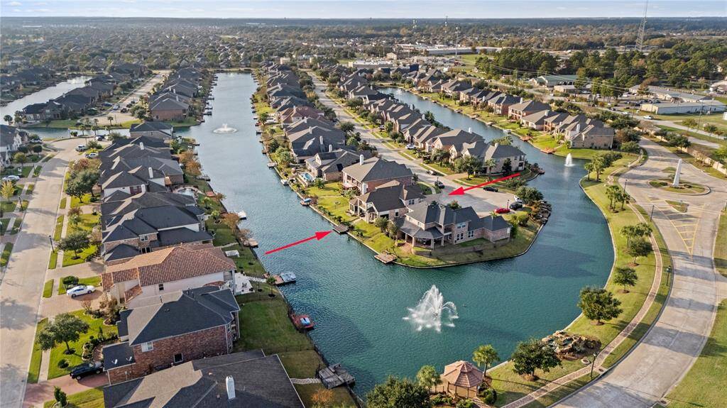 Aerial view of the picturesque waterfront community, highlighting the property’s prime location with direct access to the serene canal and close proximity to beautiful fountains and scenic walkways.