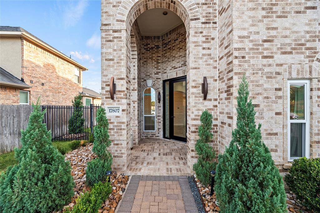 Inviting front entry with a high ceiling and bricked porch.