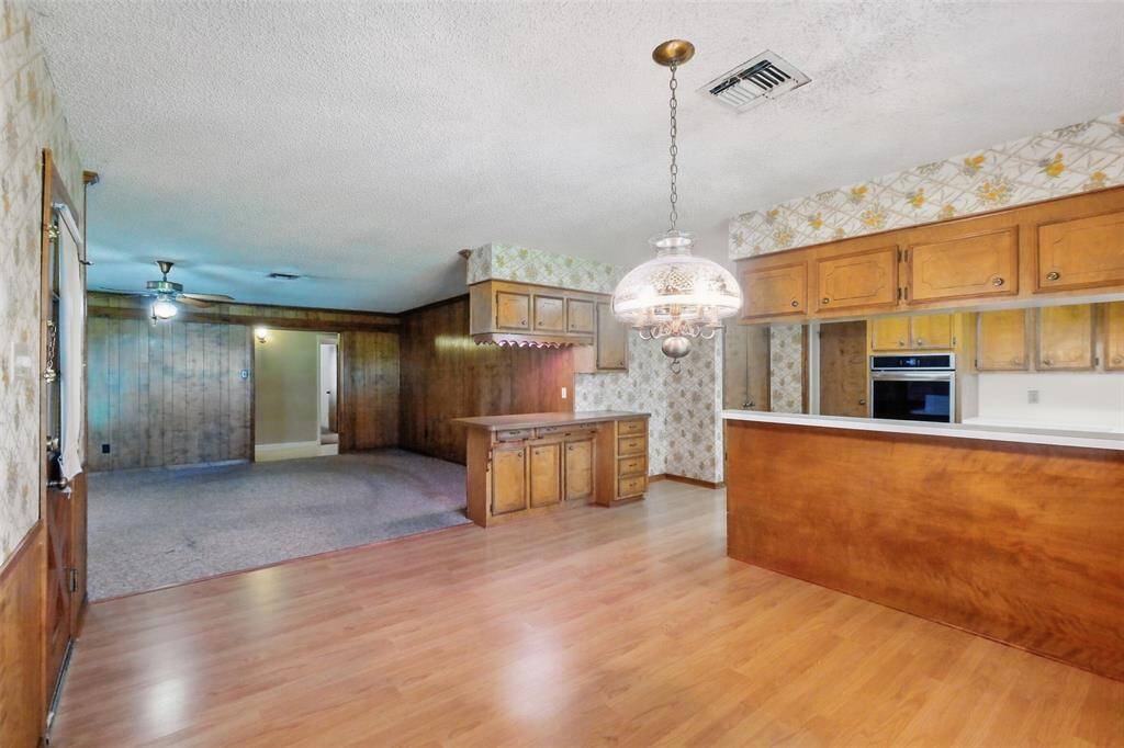 The Dining Room, Kitchen, and Family Room as seen from the Back door. The Breakfast/Serving Bar are prominently viewed at right center in this scene.
