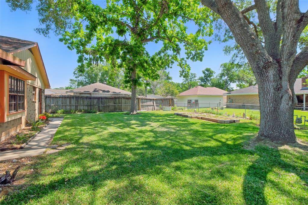 This Backyard is covered with carpet grass and mature trees... A Texas Tradition!