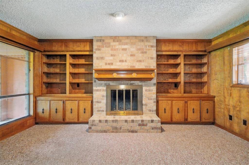 A detail view of the Brick Fireplace flanked by Custom Shelving and Storage.