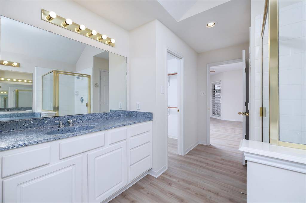 Vanity and glass shower in primary bath.
