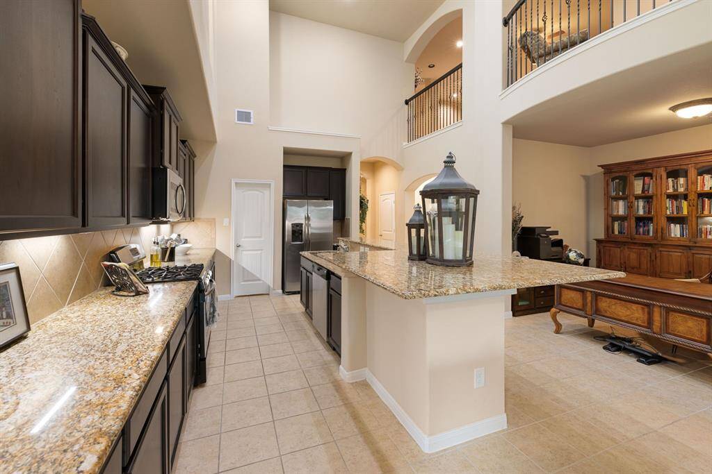 Imagine enjoying your favorite snack or beverage in this inviting space, illuminated by warm under cabinet lighting. A spacious walk-in pantry provides ample storage for all your culinary needs.