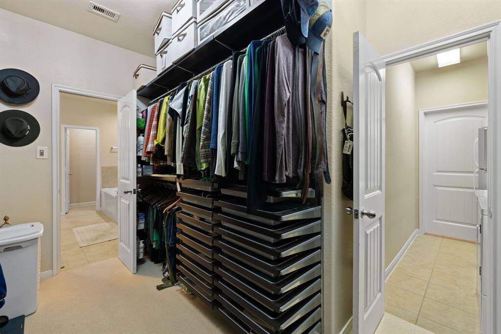 The primary closet is designed with Elfa shelving and wood fascia, providing a versatile and organized space for all your belongings.