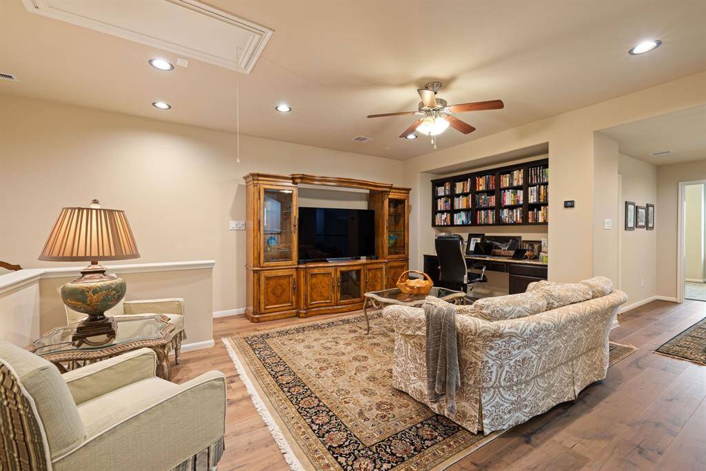 The upstairs game room boasts beautiful hardwood floors, dedicated office space, and recessed lighting, all within an open-concept design.