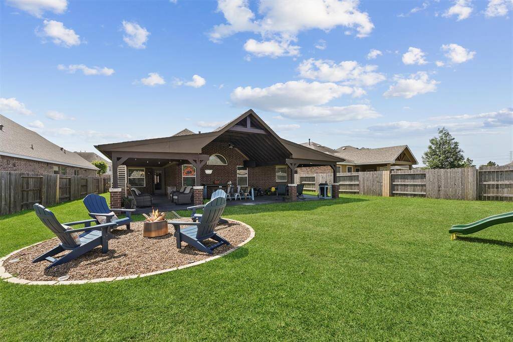 The huge backyard is an entertainer’s dream, featuring a covered patio perfect for outdoor dining and relaxation.