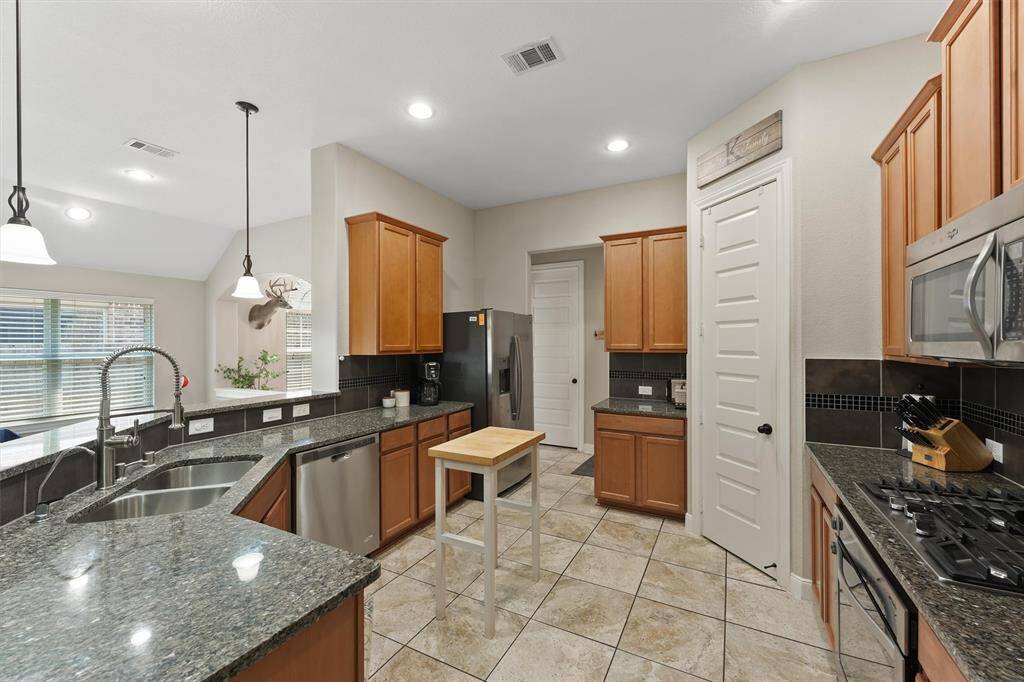 The kitchen, which opens to the family room, features granite countertops, stainless steel appliances and a layout that’s perfect for everyday living and entertaining.
