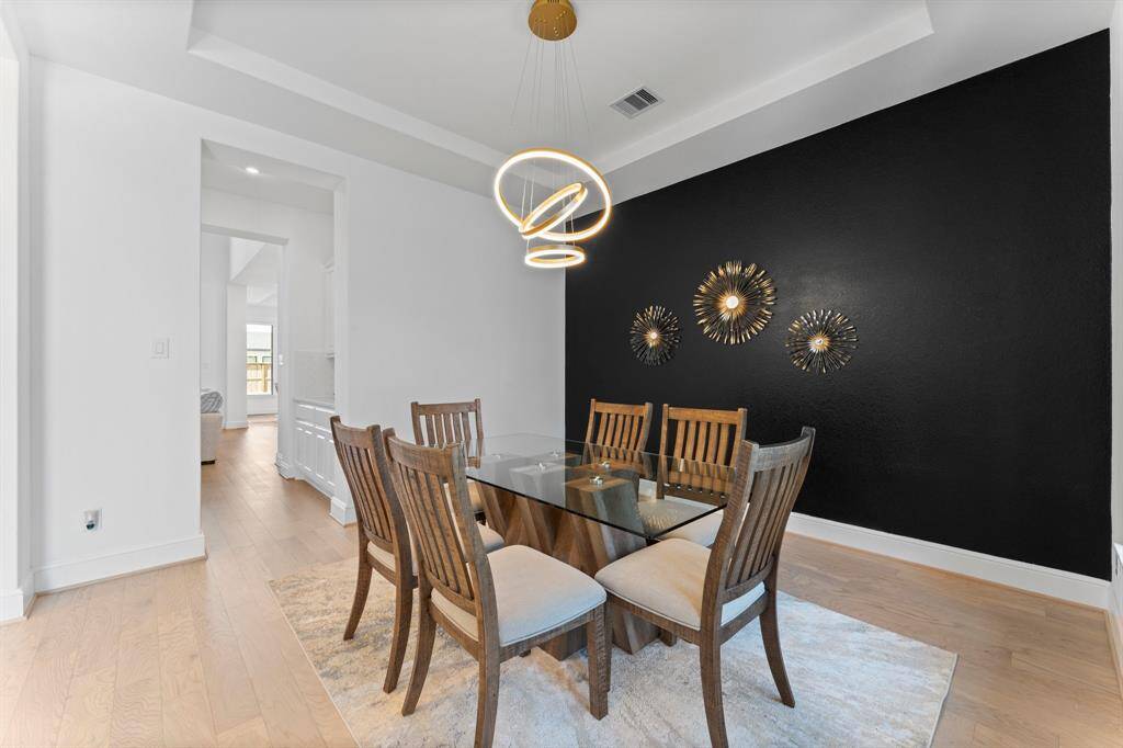 This dining room makes a statement with its sleek lighting, bold accent wall, and modern elegance. Leads directly into the lovely butler's pantry then kitchen!