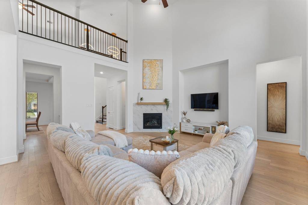The oversized family room features soaring two story ceilings and a modern sleek fireplace!