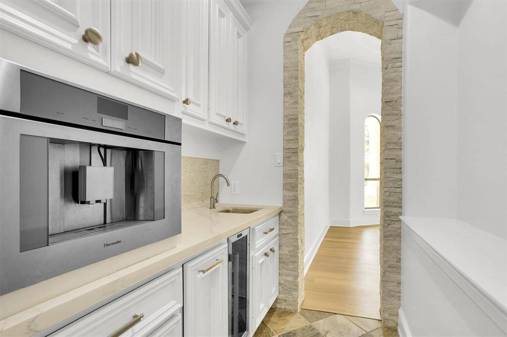 A service area that is connected between the dining room and the kitchen area is perfect for you! This service area has a built in coffee maker, beautiful cabinets, and a sink!