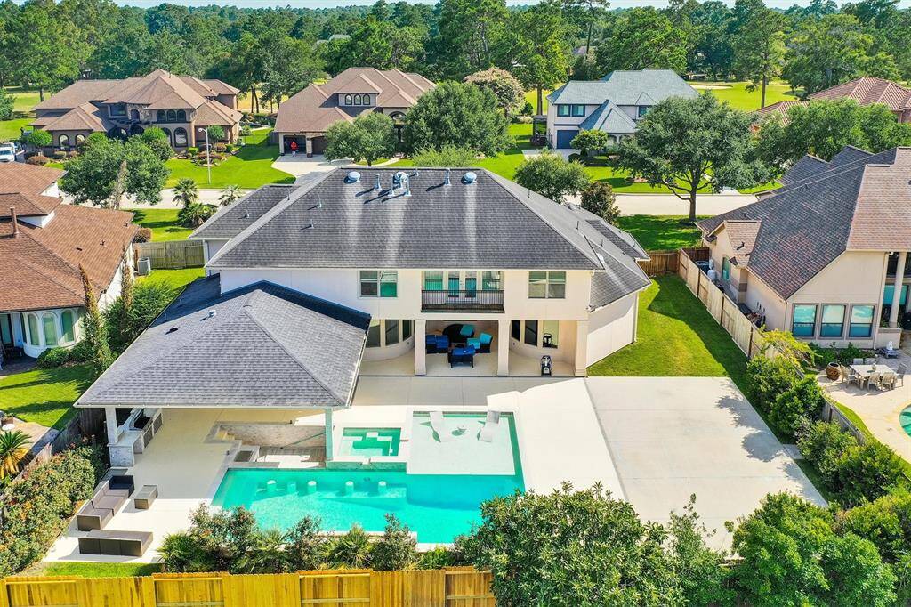 Your backyard is an ideal retreat, perfect for relaxing with family or friends. It features a large pool, an outdoor kitchen, a covered patio with ample seating, a swim-up bar with a sink, and extra space for a basketball court or playground for even more entertainment options.