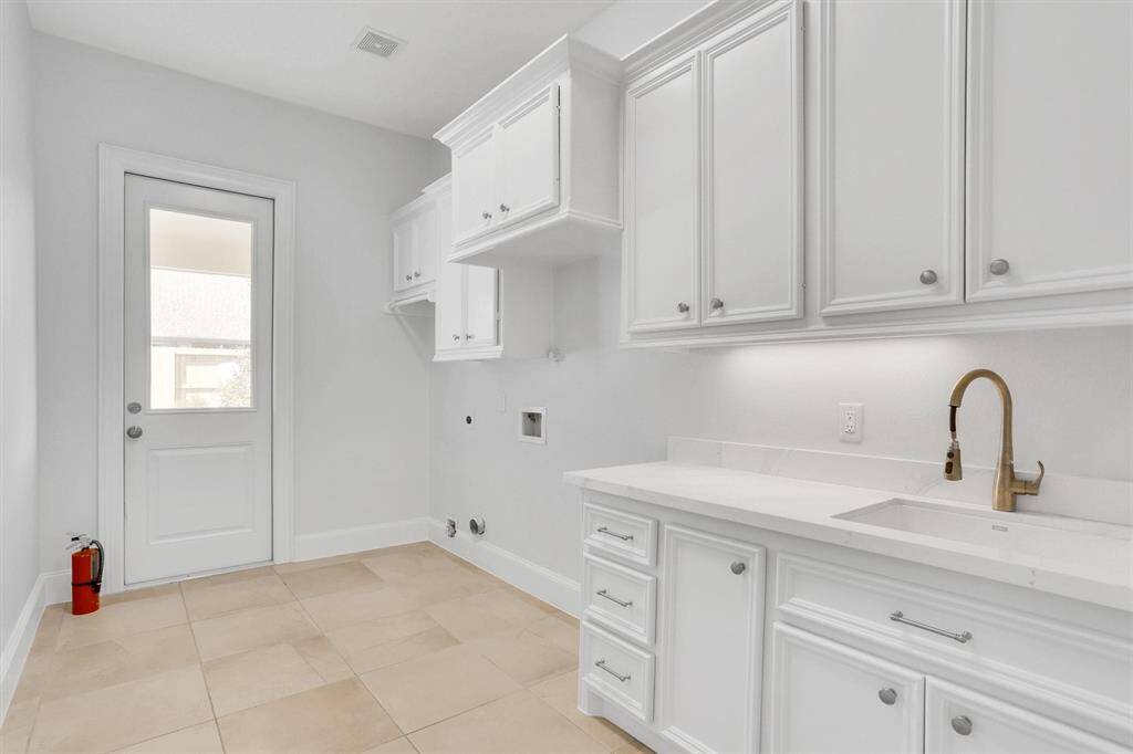 Large utility room with a sink and plenty of storage. T