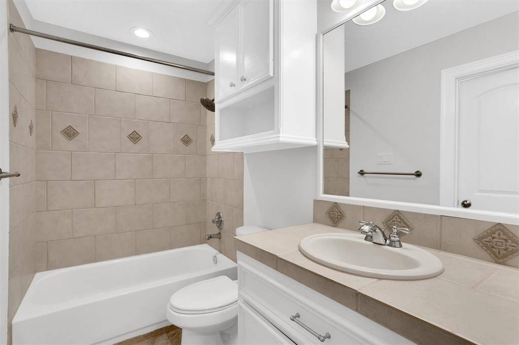 Lovely secondary bathroom complete with recessed lighting, tile floors and plenty of wooden cabinetry.
