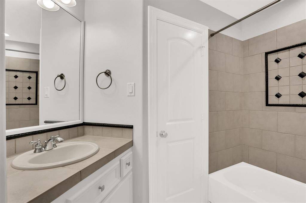 Lovely secondary bathroom complete with recessed lighting, tile floors and plenty of wooden cabinetry.