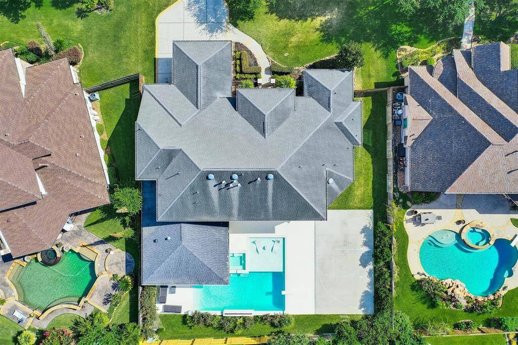 Your backyard is an ideal retreat, perfect for relaxing with family or friends. It features a large pool, an outdoor kitchen, a covered patio with ample seating, a swim-up bar with a sink, and extra space for a basketball court or playground for even more entertainment options.
