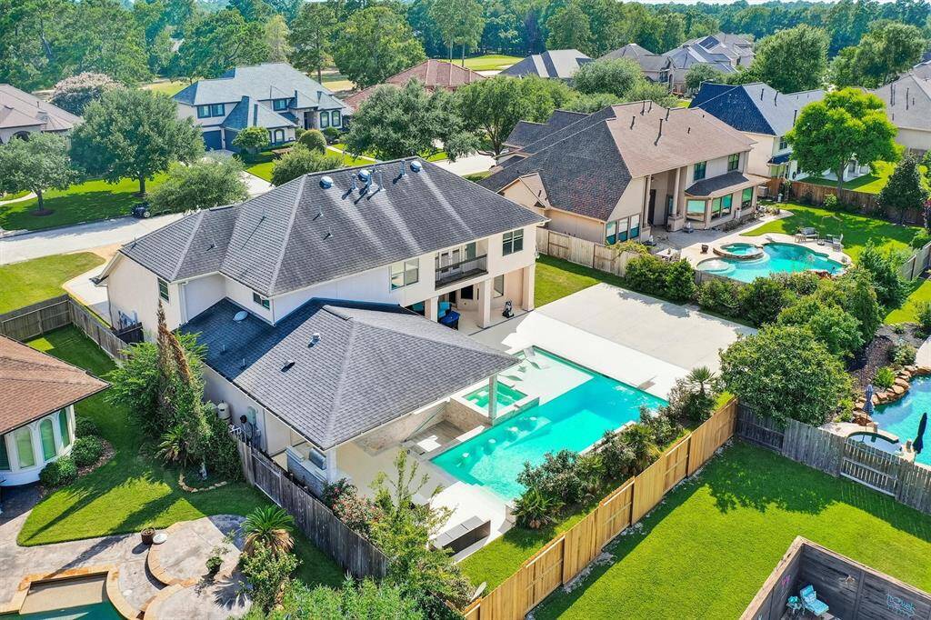 Your backyard is an ideal retreat, perfect for relaxing with family or friends. It features a large pool, an outdoor kitchen, a covered patio with ample seating, a swim-up bar with a sink, and extra space for a basketball court or playground for even more entertainment options.