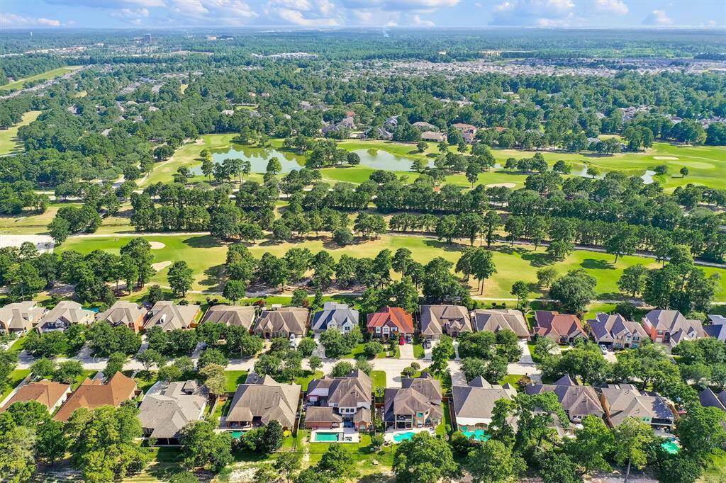 Eaglewood At Oakhurst in Porter, Texas, is a picturesque suburban community characterized by well-maintained single-family homes, many with pools and spacious yards, nestled along wide streets. The neighborhood is surrounded by lush greenery and is adjacent to a manicured golf course, enhancing its scenic and serene atmosphere. This planned community emphasizes outdoor living and recreational opportunities, making it an appealing environment for families.