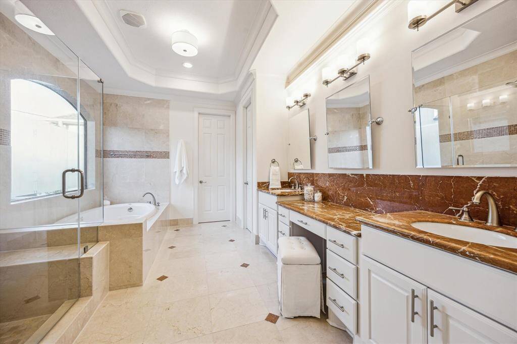 Primary en suite bath with double sinks, makeup station, large private shower and tub with one of the two large primary closets