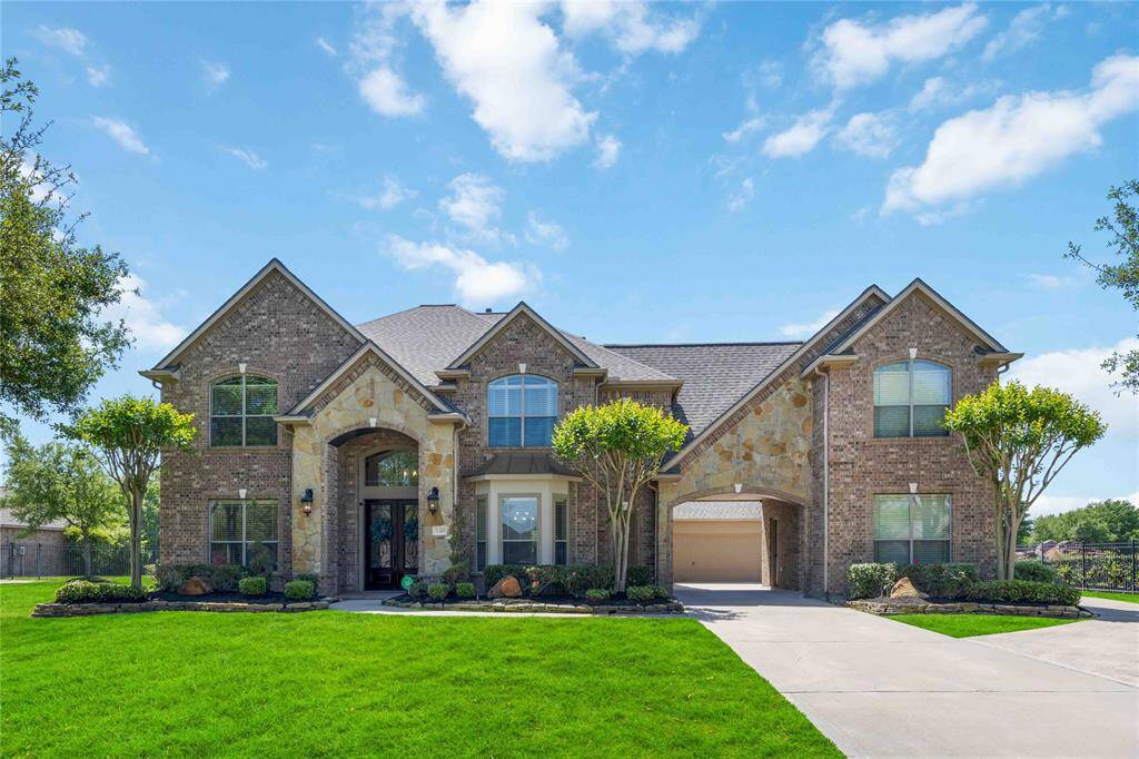 Welcome to 21207 Fairhaven Creek Drive where charming curb appeal meets inviting warmth. The front façade features a beautifully landscaped yard with neatly trimmed shrubs.