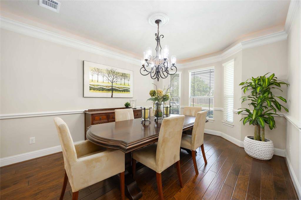 The formal dining room is large and inviting, featuring ceilings adorned with elegant crown molding that adds a touch of sophistication.