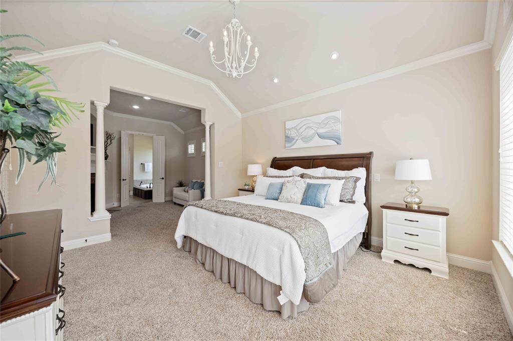 Primary bedroom featuring a view of the sitting area and an en-suite bathroom.