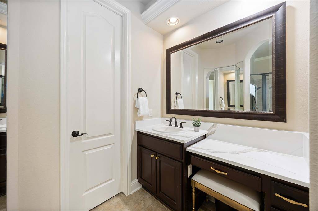 Bathroom featuring a sink, vanity, sitting area and ample storage with drawers.